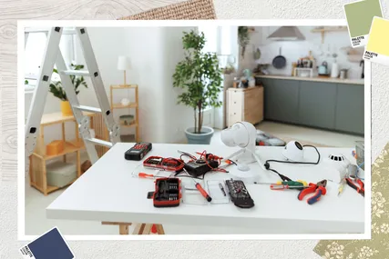 A table with tools and electrical components a ladder and plants in the background
